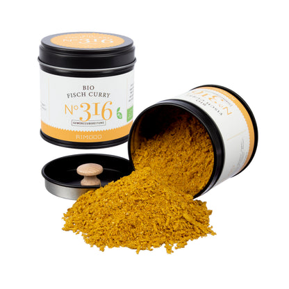 Eine Dose Bio Curry Gewürz-Set N°2 steht, eine liegt und gemahlenes Gewürz ist ausgeschüttet.
