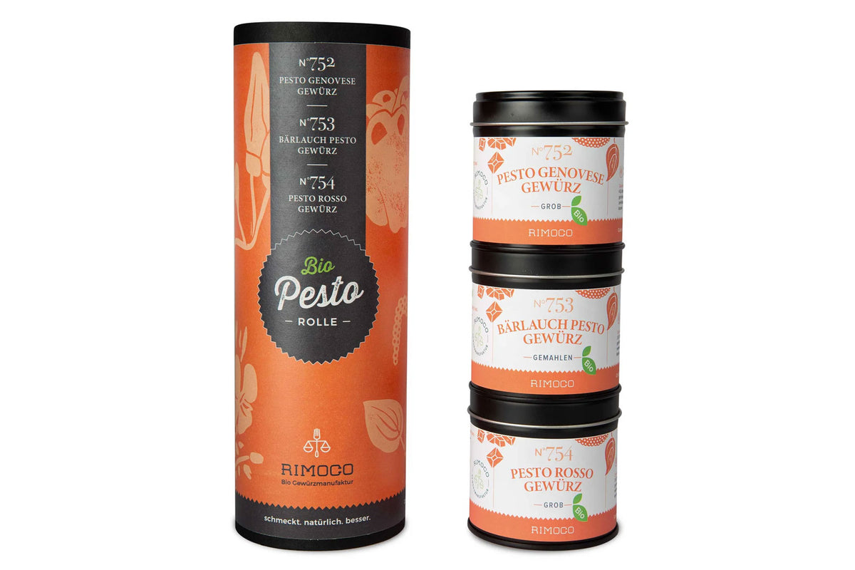 Drei gestapelte Gewürzdosen und ein hoher orangefarbener Behälter mit der Aufschrift „Bio Pesto Rolle“.