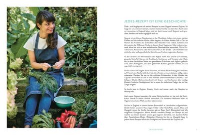 Eine lächelnde Frau im Garten hält frisches Gemüse und ein Buch mit dem Titel Indisch Vegetarisch.