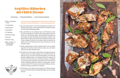 Gegrilltes Hähnchen mit Chilischoten und Zitronenscheiben auf einem Grillrost.