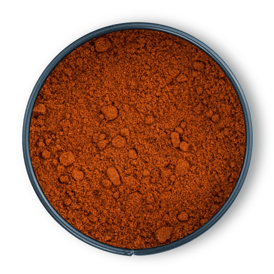 Rundes Gefäß mit fein gemahlenem, rötlich-braunem Bio Ancho Chili von oben gesehen.