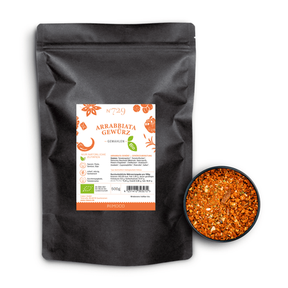 Bio Arrabbiata Gewürz neben einer Schale mit leuchtend rot-orangem, gemahlenem Gewürz.