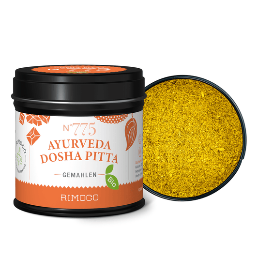 Offene Dose mit Aufschrift Bio Ayurveda Dosha Pitta, im Deckel gelbes Gewürzpulver sichtbar.
