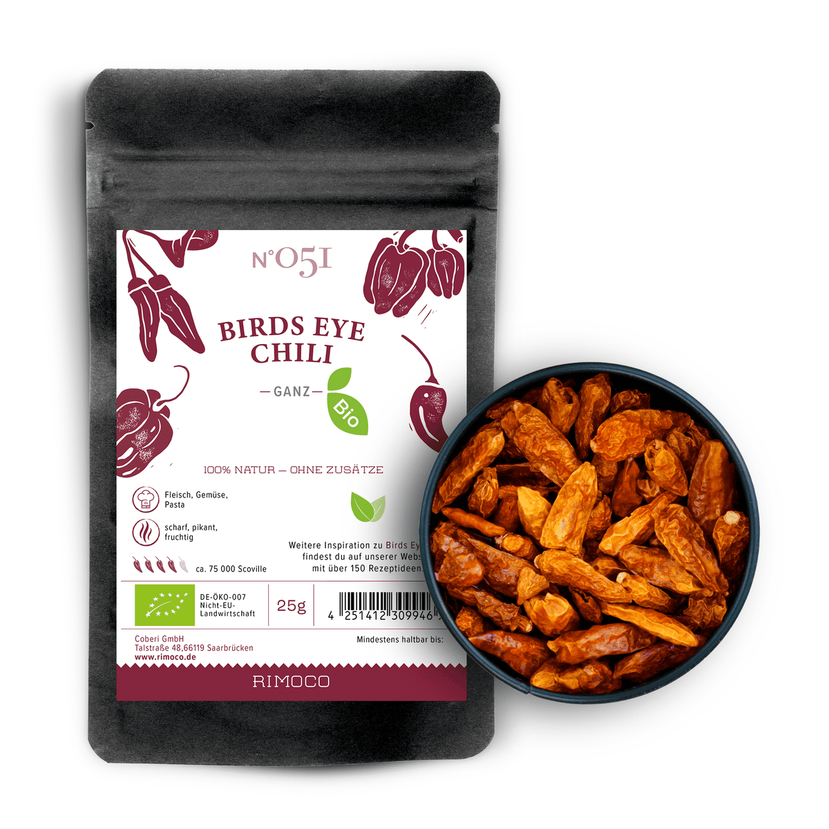 Bio Birds Eye Chili Packung neben einer Schale mit getrockneten roten Chilis auf weißem Hintergrund.