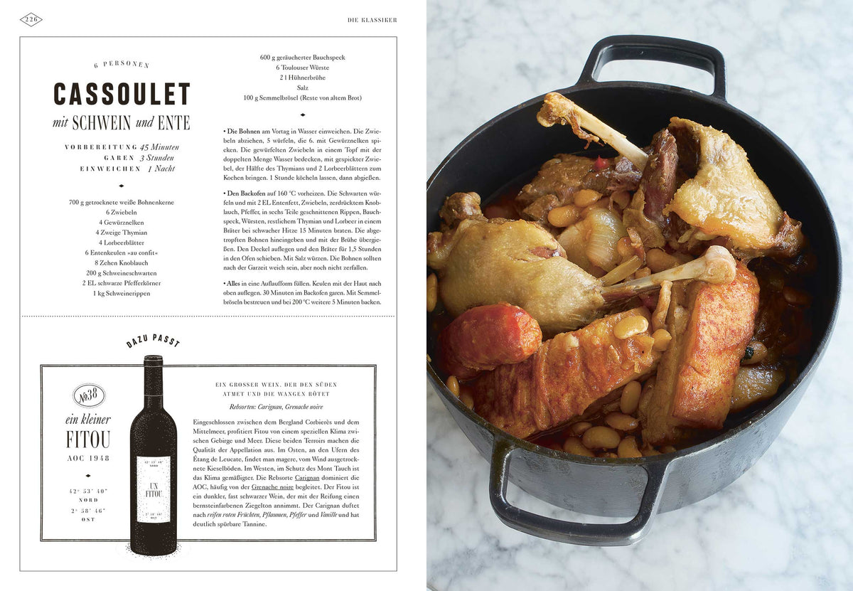 Ein Topf Cassoulet mit Wurst, Ente und Bohnen steht neben Bistro, Bistro! auf der Arbeitsplatte.