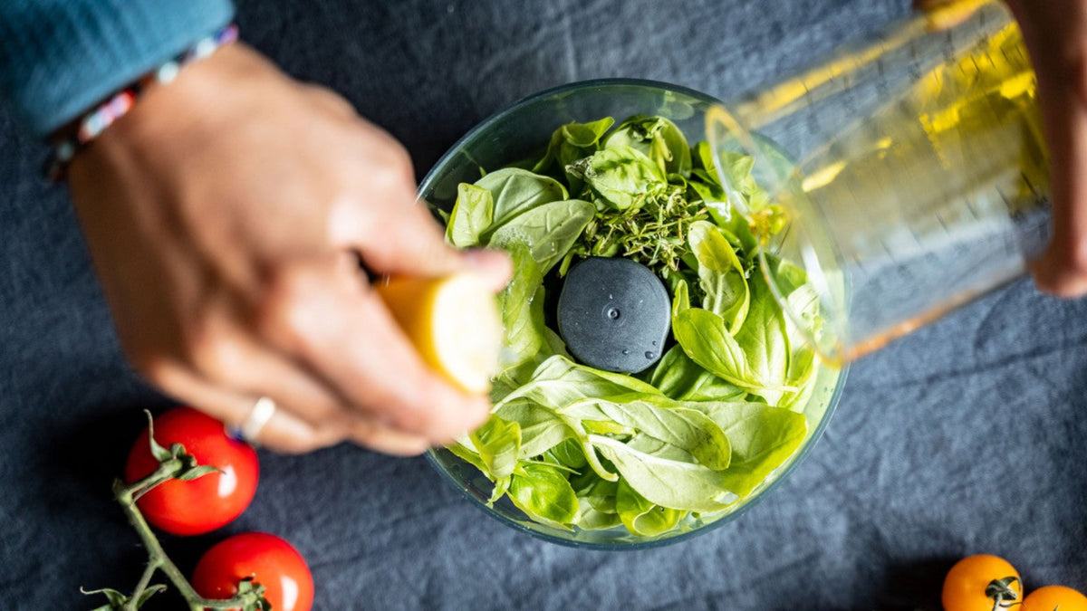 Geben Sie Öl und Zitronensaft in einen Mixer, dazu frisches Basilikum und reife Tomaten.