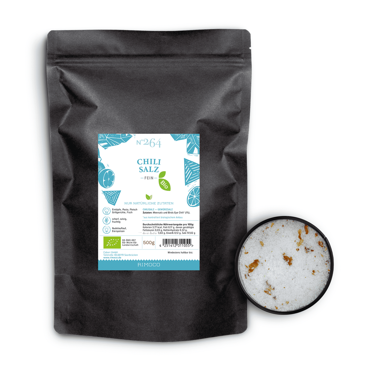 Schwarze Tüte Bio Chilisalz, daneben eine Schale mit grobem Salz und Birds Eye Chili Flocken von oben.