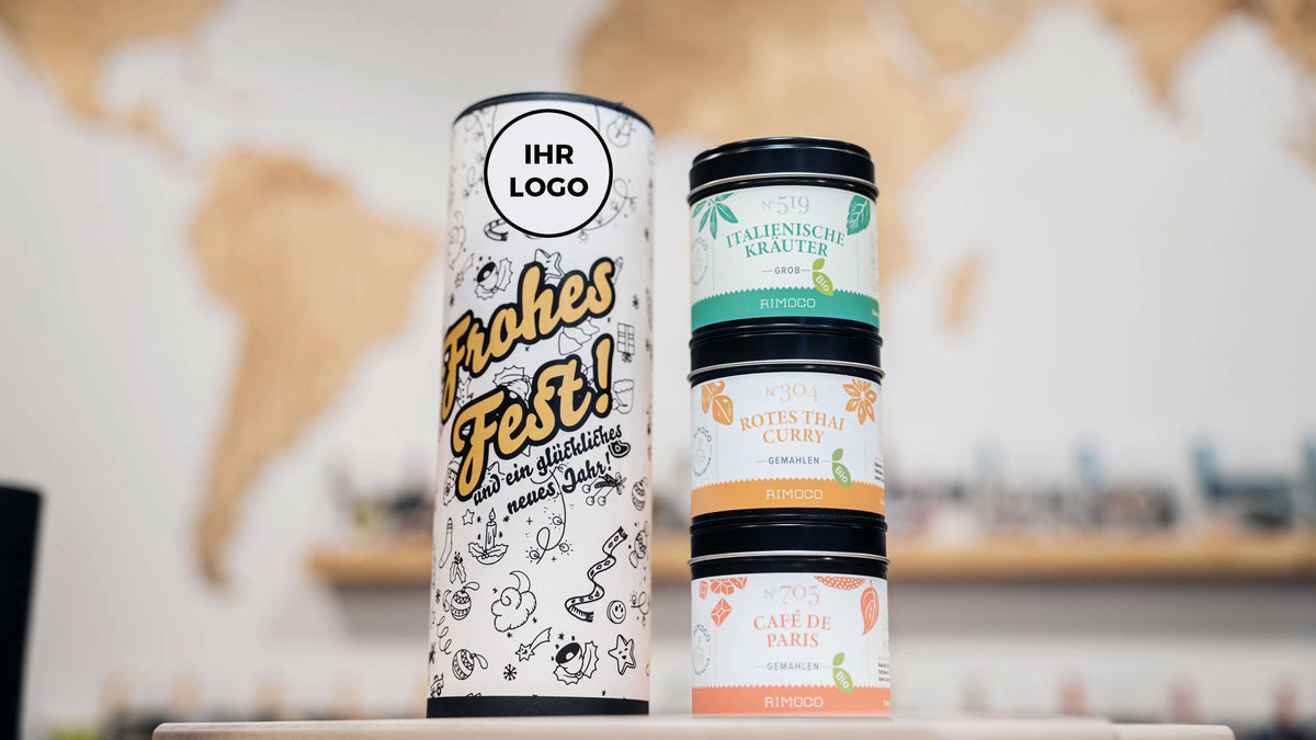 Drei Bio-Gewürze neben Geschenkrolle mit eigenem Logo als Option für Firmengeschenke