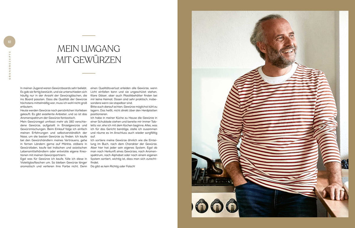 Lächelnder Mann im gestreiften Hemd steht am Herd mit Geschenkset Gewürze - Das Kochbuch, schaut nach rechts.