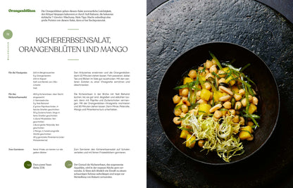 Eine Schüssel Kichererbsensalat mit Mango und grünen Blättern, daneben Geschenkset Gewürze - Das Kochbuch.