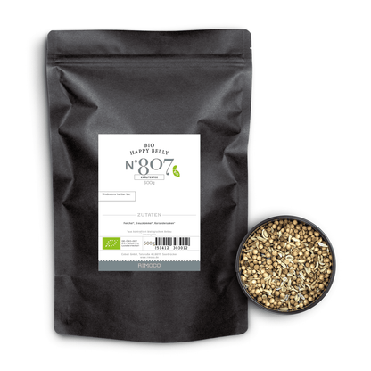 Bio Ayurveda Tee Happy Belly neben einer Schale mit ganzen Fenchel- und Hanfsamen.