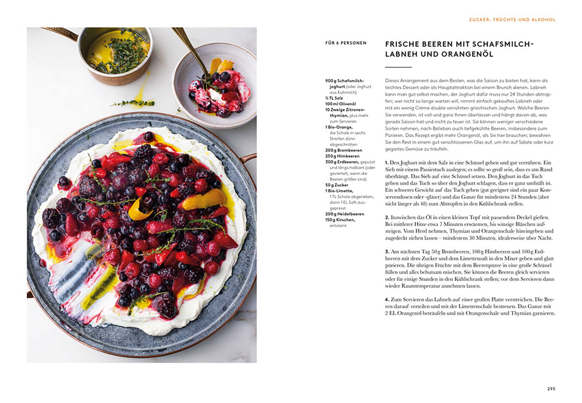 Ein Teller mit Schlagsahne, gemischten Beeren, Orangenscheiben und Geschenkset Ottolenghi Flavour daneben.