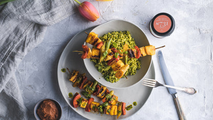 Gegrillte Gemüsespieße mit grünem Reis, dazu BBQ Rub sowie eine teilweise sichtbare Geschenkbox.
