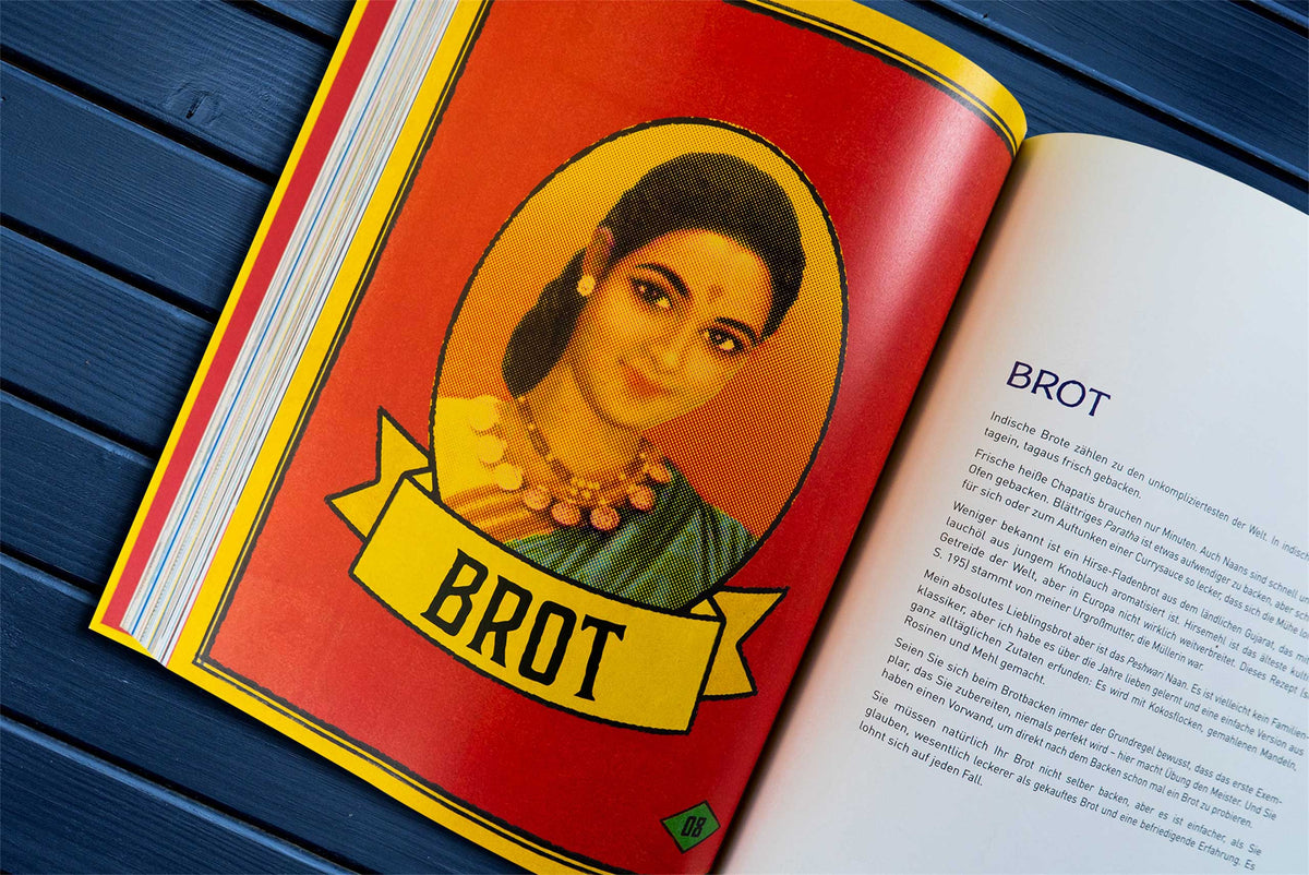 Offenes Buch mit Geschenkset Original Indisch und vegetarischen Rezepten auf rot-gelber Seite.