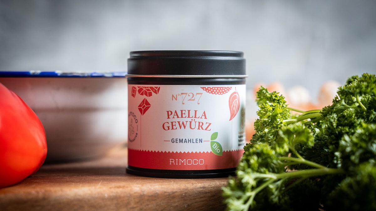 Rimogo Paella-Gewürzmischung in einer Dose mit Tomaten, Petersilie und Eiern auf dem Etikett.
