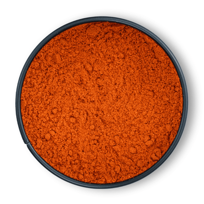 Runde schwarze Schale mit leuchtend rotem, gemahlenem Bio Paprikapulver, von oben gesehen.
