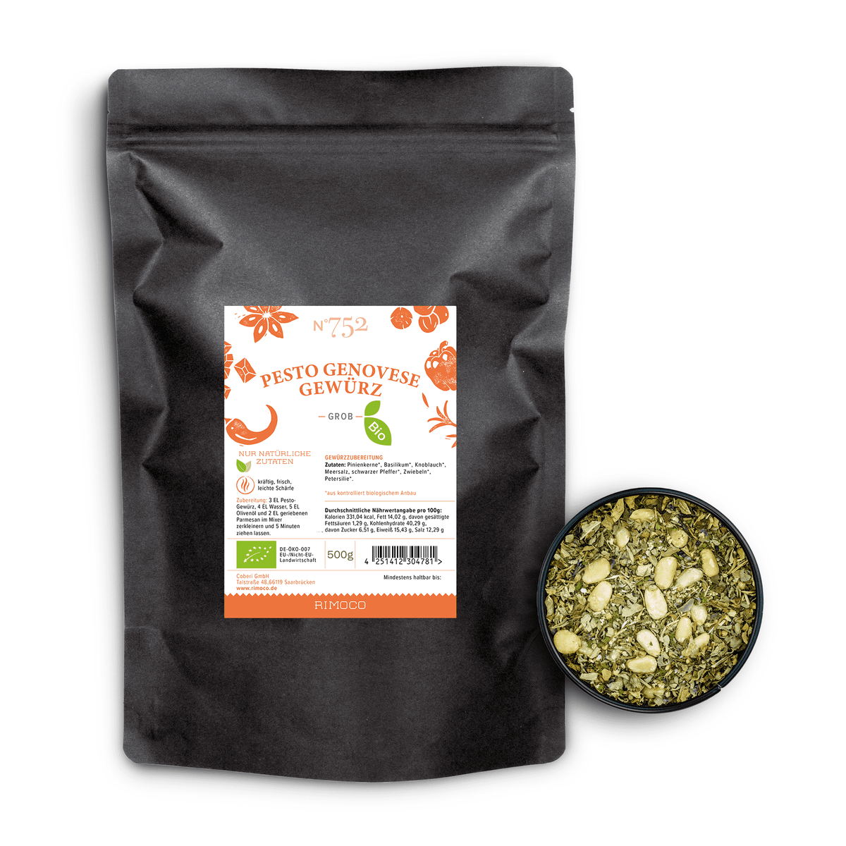 Schwarzer Beutel mit Aufschrift Bio Pesto Genovese neben einer Schale mit grünen Kräutern und Pinienkernen.