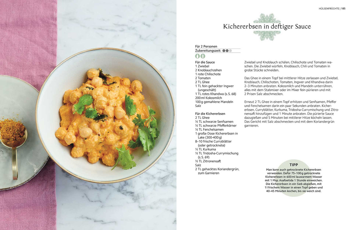 Kichererbsen in cremiger orangener Sauce, mit Koriander bestreut.