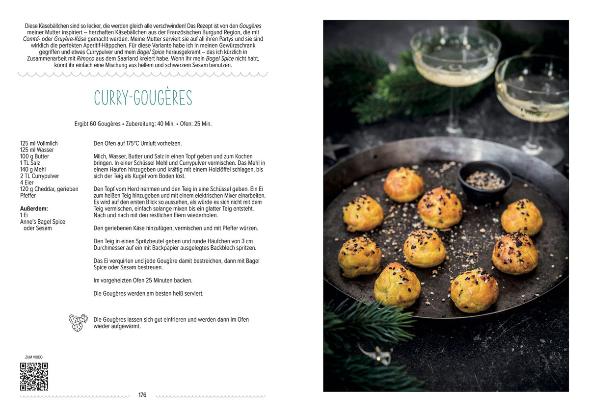 Ein Tablett goldener Curry-Gougères mit Samen, serviert neben einem Glas Sekt.