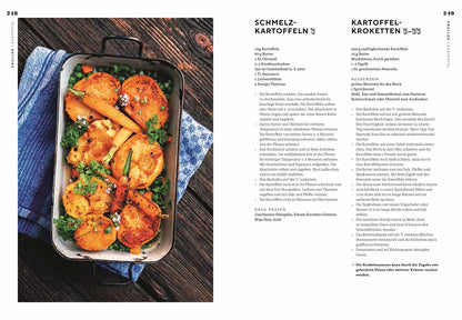 Geröstete Kartoffeln und Karotten mit sichtbaren Kräutern in einer weißen Auflaufform.