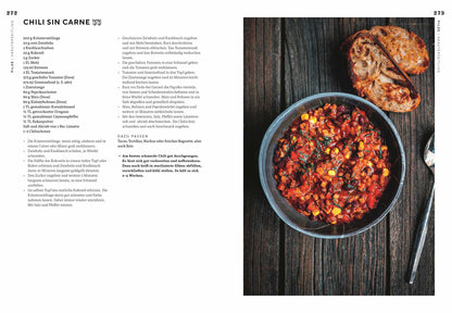 Chili sin carne mit Mais, Bohnen und Kräutern, dazu geröstetes Brot auf Holzfläche.