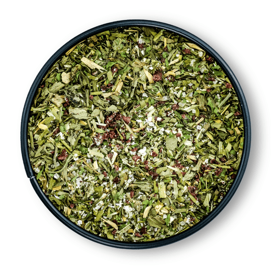 Runde Dosis Bio Salatgewürz mit grünem, getrocknetem Kräuter-Gewürz-Mix von oben gesehen.