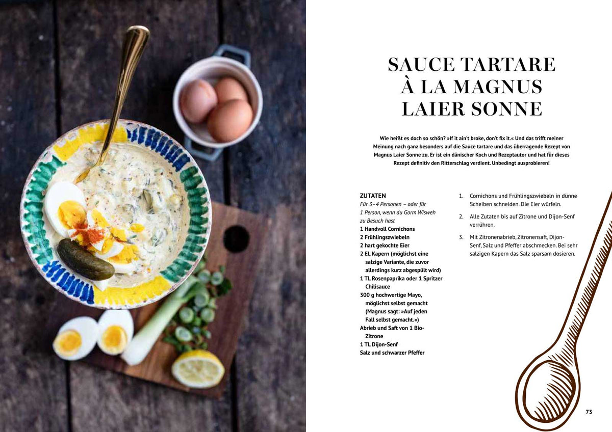 Eine Schale Tartarsauce mit Zitronen, Eiern und Kapern auf dem Tisch.