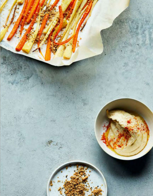 Bunte Ofenkarotten mit Hummus auf einem Teller, Rezept aus Simple & Clever Kochbuch.
