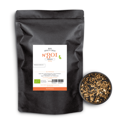 Bio Spicy Chai Tee in schwarzer Tüte, daneben eine Schale mit losen Teeblättern auf weißem Hintergrund.