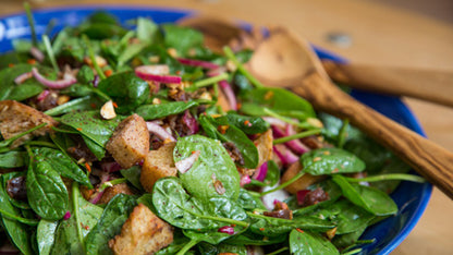 Spinatsalat mit Croutons, roten Zwiebeln, Nüssen und einer Flasche Bio Balsamico Condimento Bianco.