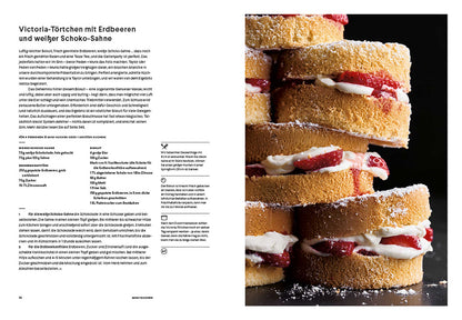 Mini Victoria Sponge Cakes mit Sahne und Erdbeeren aufgeschnitten, Kuchen auf einem Teller serviert.