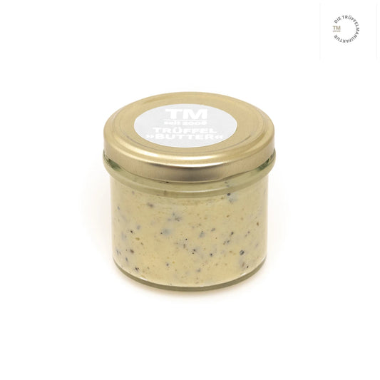 Trüffelbutter in kleinem Glas mit goldenem Deckel.